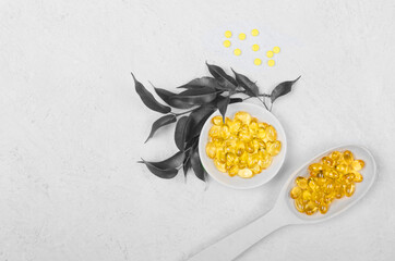 Demonstrating colors of year 2021. Gray and Yellow. Yellow pill on wooden spoons on grey background