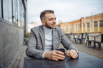 Photo portrait of smiling businessman drinking coffee in cafe looking at side in checkered suit