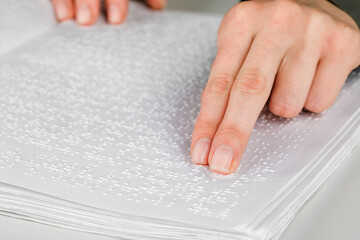 A woman reads a book written in Braille.