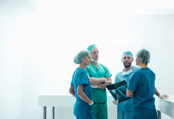 Female and male surgeons discussing over medical x-ray in hospital