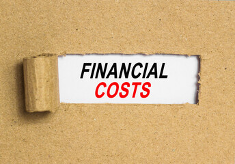 The text FINANCIAL COSTS. behind torn brown paper. Business Concept image.