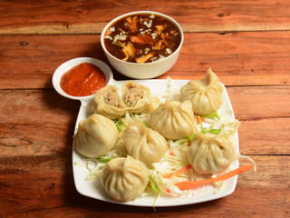 Chicken steam momo and chicken soup, Nepalese Traditional dish Momo stuffed with chicken and then cooked and served over a rustic wooden background, selective focus