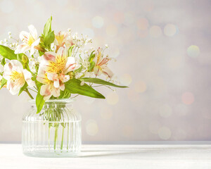 Fresh delicate white flowers freesia with funny glass vases in green mint menthe interior on white wood board, copy space.