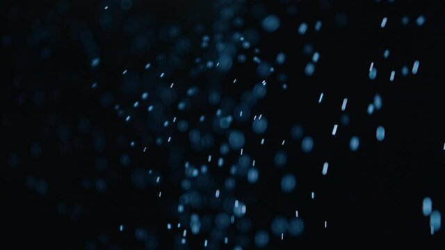 Abstract motion background, particles, dust, snow. Dark.