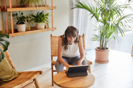 Smiling mature woman using digital tablet while sitting at home