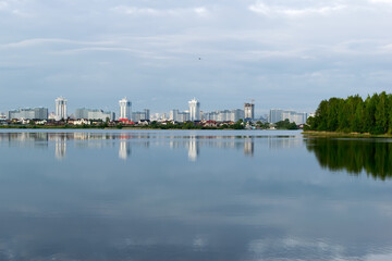 city with tall houses is reflected in the lake