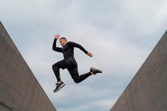 Athlete jumping on wall against sky