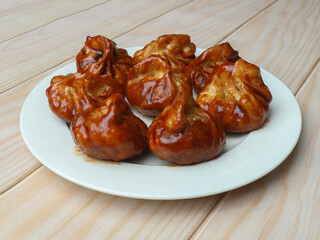 Veg momo with barbeque sauce served over a rustic wooden background, selective focus