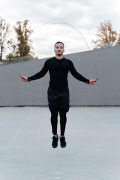 Young man skipping rope while exercising outdoors