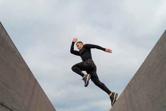 Sportsman jumping on wall against sky