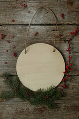 Blank wooden circle board in festive Christmas setting in rustic wooden background.
