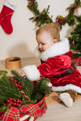Little cute boy dressed as Santa near little Christmas trees. Christmas mood