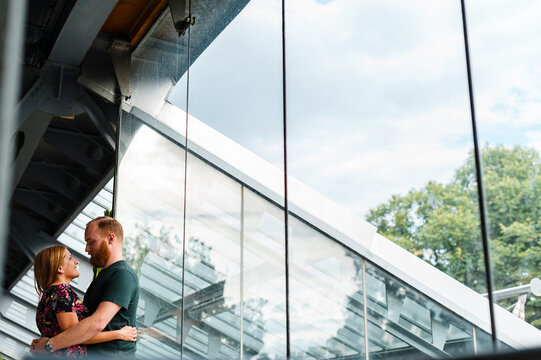 Heterosexual couple embracing each other against glass window