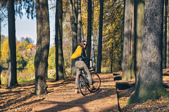 Woman looking over shoulder while riding bicycle in public park