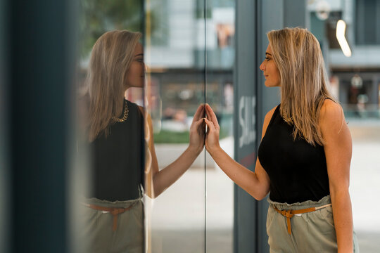 Mid adult woman doing window shopping while standing by store window
