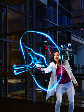 Female internist light painting spleen in laboratory at hospital