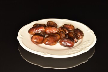 Sweet dried dates, close-up, on a black background.