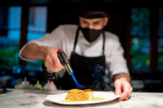 Chef preparing pudding while giving flame in restaurant kitchen