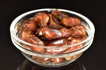 Sweet dried dates, close-up, on a black background.