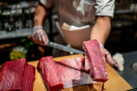 Male chef showing slice of raw seafood in kitchen at restaurant