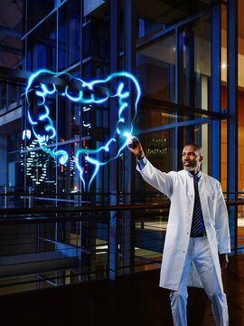 Male gastroenterologist examining large intestine with light painting at hospital