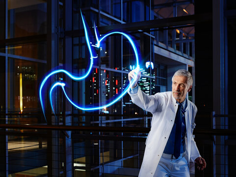 Male gastroenterologist light painting esophagus in laboratory at hospital