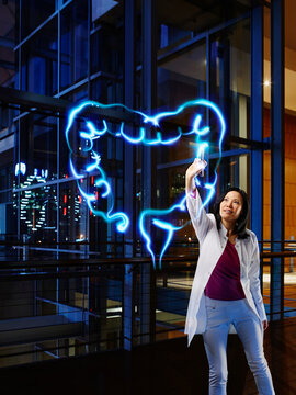 Female gastroenterologist examining large intestine with light painting at hospital
