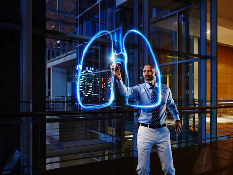 Male pulmonologist light painting lung in laboratory at hospital