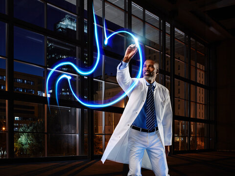 Male gastroenterologist light painting stomach in laboratory at hospital