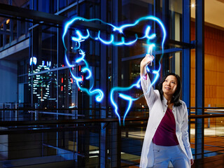 Female gastroenterologist analyzing large intestine with light painting at hospital