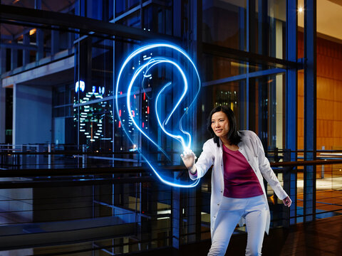 Female otolaryngologist examining ear with light painting in laboratory at hospital