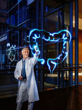 Male gastroenterologist examining large intestine with light painting at hospital