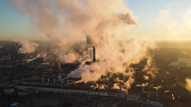Aerial view of high smoke stack with smoke emission. Plant pipes pollute atmosphere. Industrial factory pollution, smokestack exhaust gases. Industry zone, thick smoke plumes. Climate change, ecology