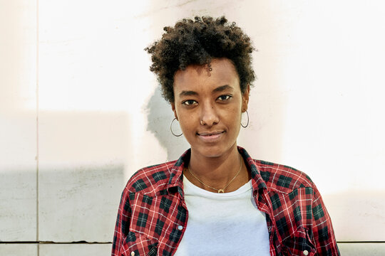 Confident Young Afro Female Hipster Against White Wall