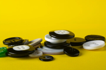 Buttons of various diameters on a yellow background.