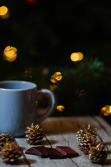 Obraz na płótnie Canvas taza de chocolate con arbol de navidad de fondo y luces de decoracion 