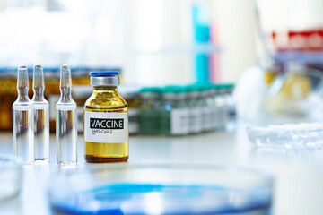 Vaccine in vial for injection on table against background of laboratory