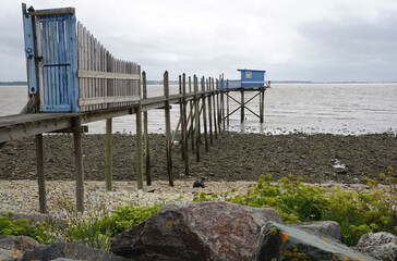 old blue wooden pier on the beach with fishing hut in Vendée, France