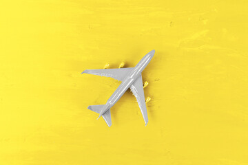 Toy plane on Illuminating Yellow background, top view