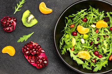 Fruit salad with arugula, tangerines and pomegranate seeds