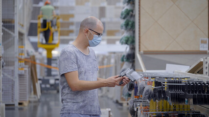 A man preparing for construction. in a construction shop chooses a spatula