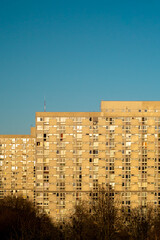 Warsaw, Poland: Old, big concrete block of flats over a clear blue sky in the golden hour. Polish real estate market.
