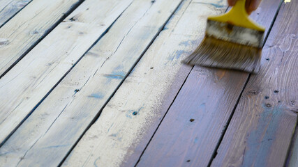 In the frame is a large brush and brown paint on the tree. Decorating the old wall board.