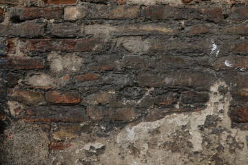 Cracked concrete brick wall with structure of white, grey and brown stones, urban and rustic stones background with space for text