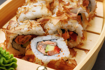 Sushi roll with tuna shavings on plate close up
