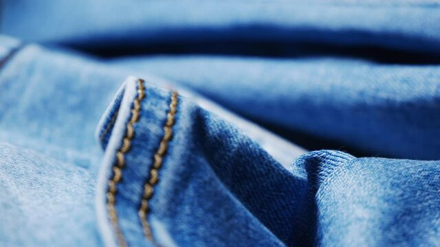 Seams on denim. Cloth texture close up. Smooth rotation. In the workshop of a fashion designer