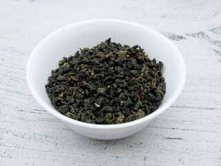 Green tea leaves milk Oolong in a white bowl. Wu long