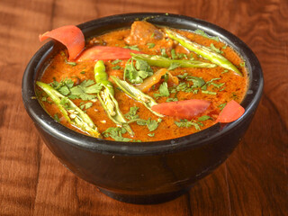 Mutton handi or Lamb curry, spicy and delicious dish served over a rustic wooden background, selective focus