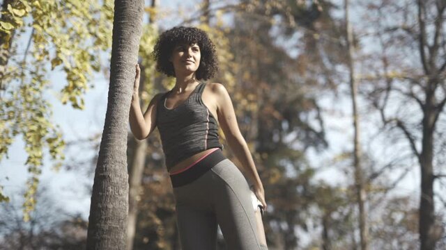 Workout routine stretches in the woods by a ebony model