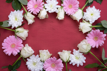 gerberas, roses and chrysanthemums are laid out in the form of an oval on a table